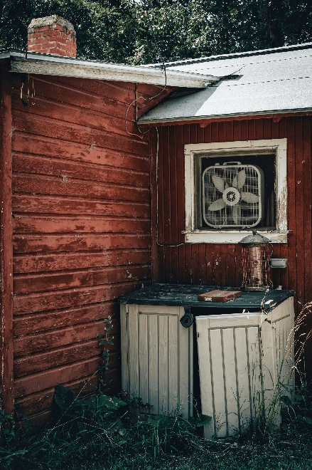 A broken cabinet outside a house.